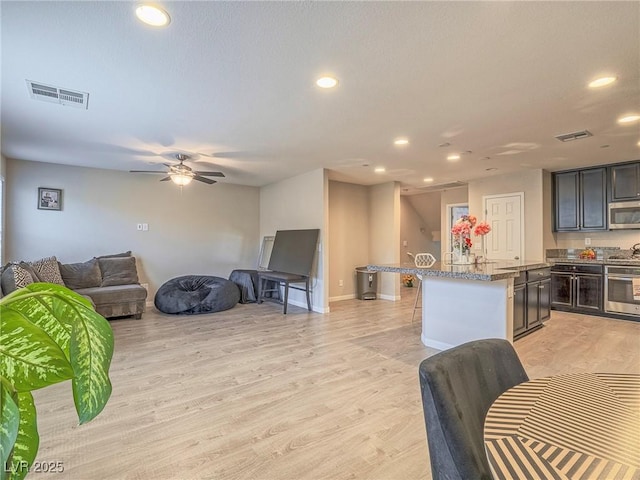 living room featuring ceiling fan and light wood-type flooring