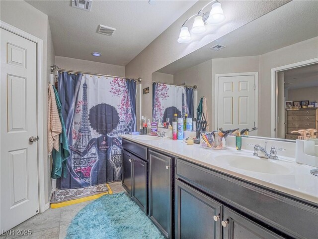 bathroom with vanity, tile patterned flooring, a shower with shower curtain, and a textured ceiling