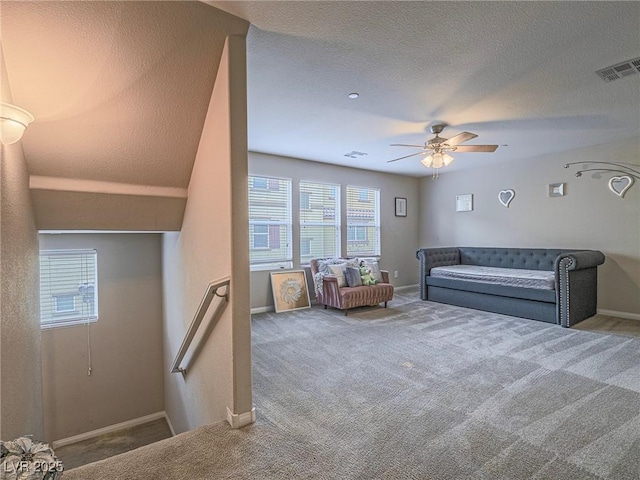 interior space with ceiling fan, carpet flooring, and a textured ceiling