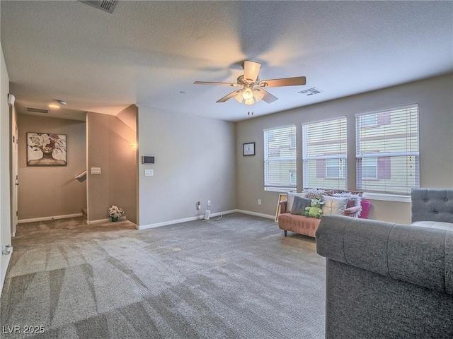 living room featuring ceiling fan, a textured ceiling, and carpet