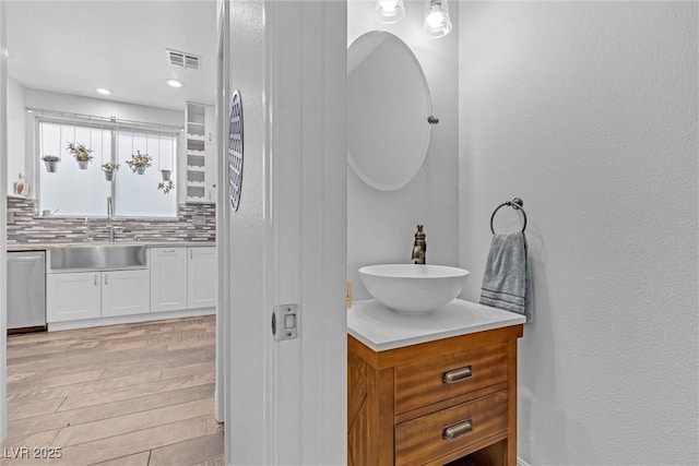 bathroom featuring vanity, decorative backsplash, and hardwood / wood-style flooring