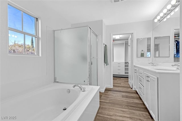 bathroom with wood-type flooring, shower with separate bathtub, and vanity