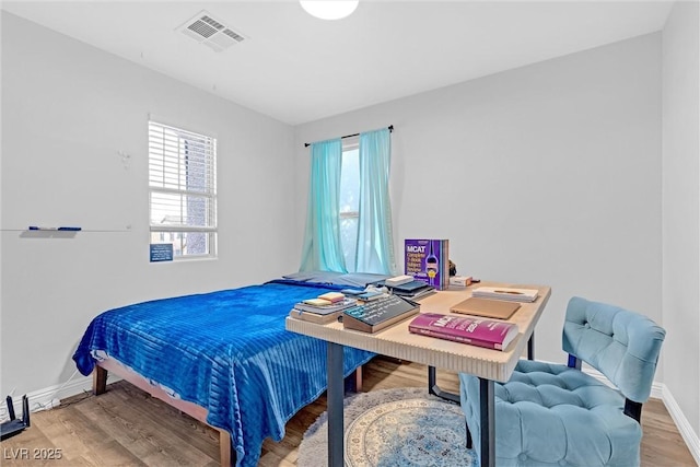 bedroom featuring hardwood / wood-style floors and multiple windows