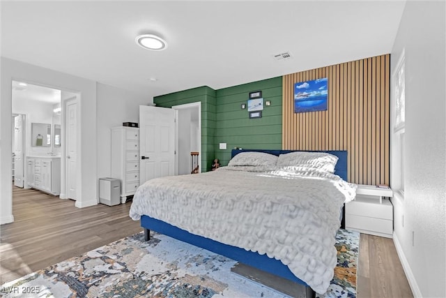 bedroom with hardwood / wood-style flooring and wooden walls