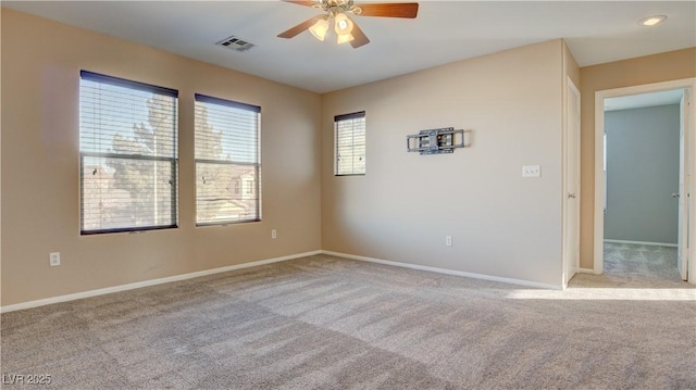 spare room featuring light carpet and ceiling fan