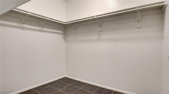 spacious closet with dark tile patterned floors