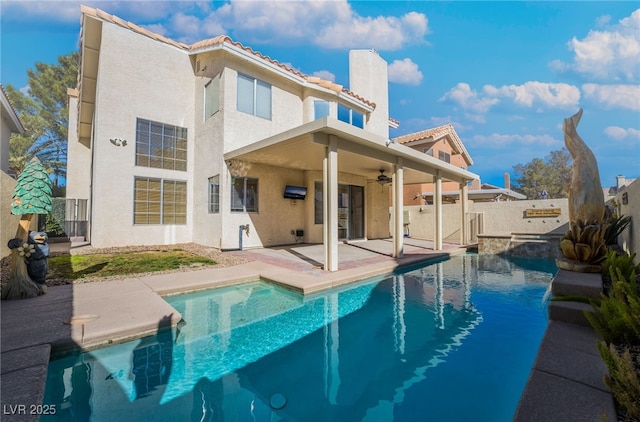 rear view of property featuring a fenced in pool, a patio, and ceiling fan