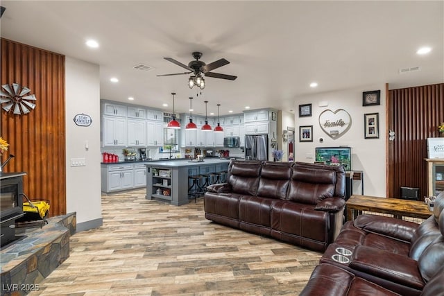 living room with ceiling fan, sink, and light hardwood / wood-style floors