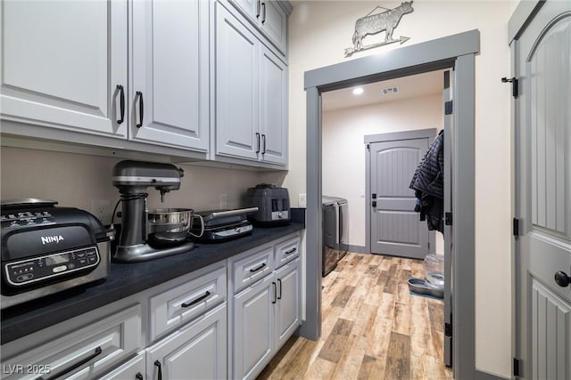 interior space with washing machine and dryer and light wood-type flooring