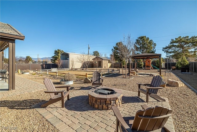 view of patio / terrace with a gazebo, a storage unit, a playground, and an outdoor fire pit