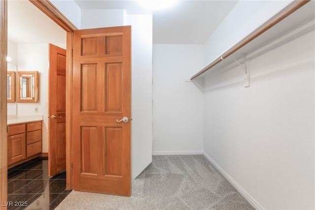 spacious closet with dark carpet