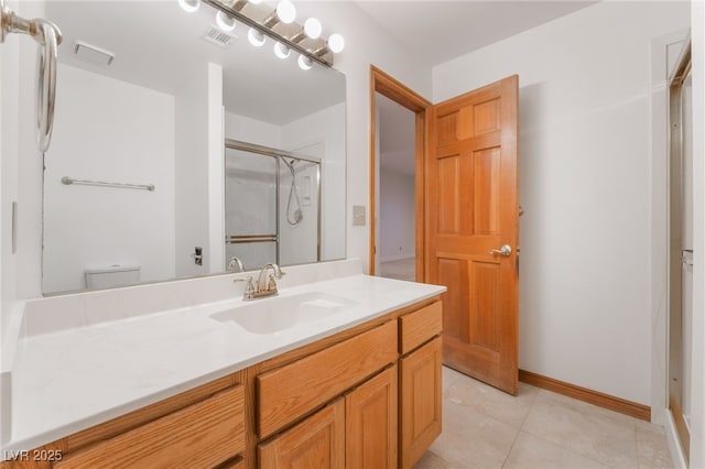 bathroom with an enclosed shower, vanity, tile patterned flooring, and toilet