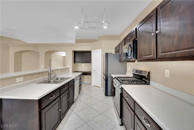 kitchen with stainless steel appliances, dark brown cabinets, sink, and light tile patterned floors