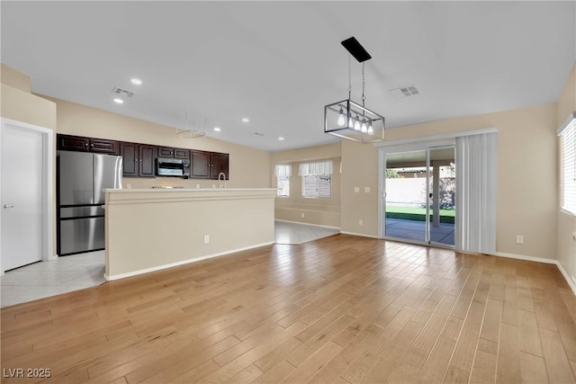 unfurnished living room featuring sink and light wood-type flooring