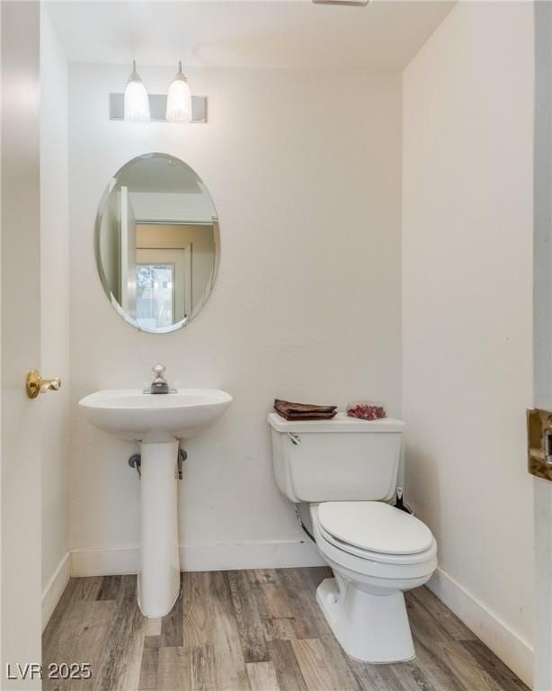 bathroom featuring hardwood / wood-style flooring and toilet