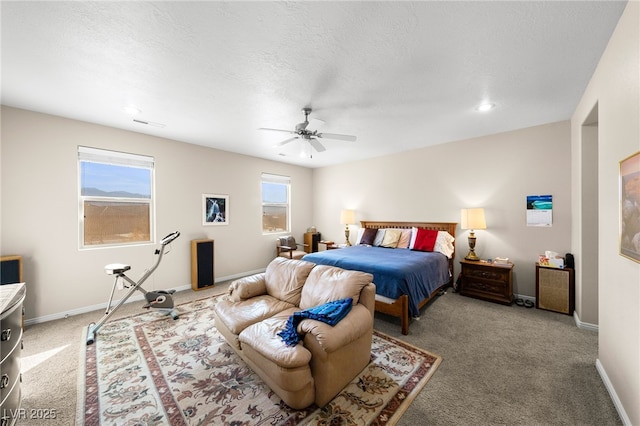 bedroom with ceiling fan, carpet floors, and a textured ceiling