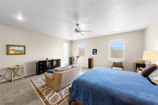 bedroom featuring ceiling fan, carpet flooring, multiple windows, and a textured ceiling