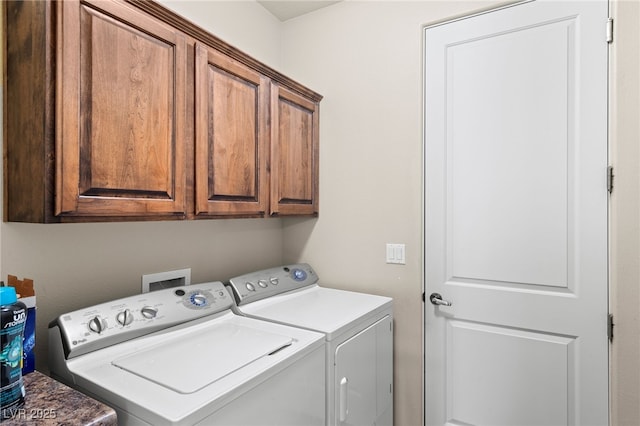 clothes washing area featuring cabinets and washing machine and clothes dryer