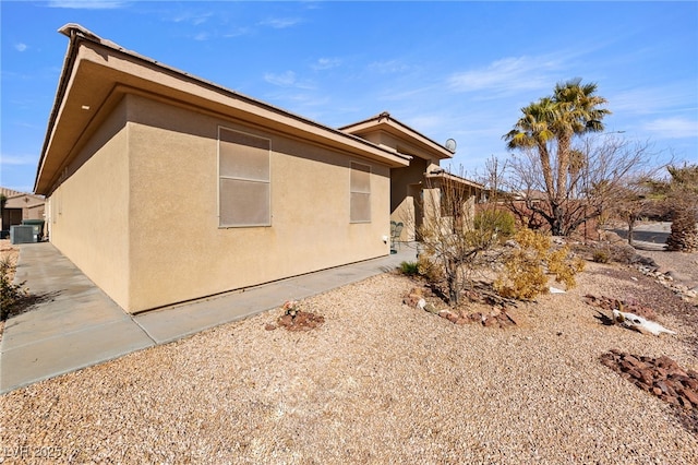 view of side of home with a patio area and central air condition unit