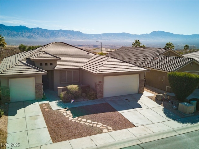 view of front of home with a garage and a mountain view