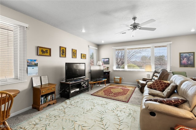 carpeted living room featuring ceiling fan and a textured ceiling