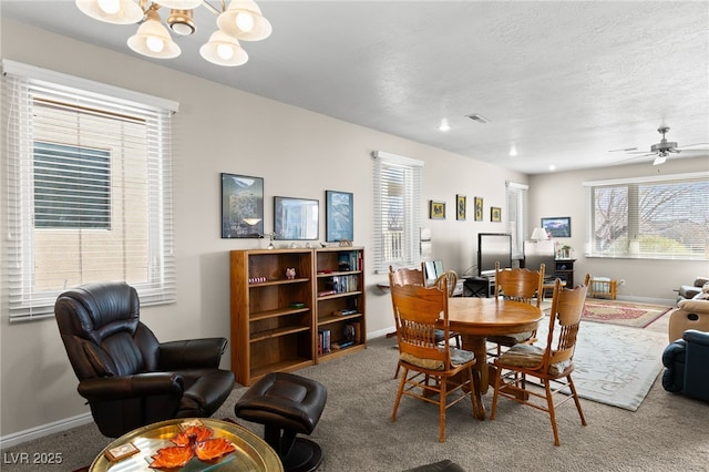 dining room with carpet flooring, ceiling fan with notable chandelier, and a textured ceiling