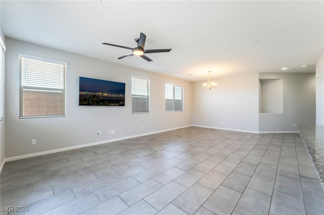 tiled empty room featuring ceiling fan with notable chandelier