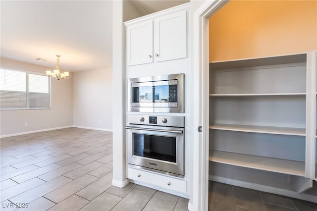 kitchen featuring light hardwood / wood-style flooring, white cabinetry, hanging light fixtures, an inviting chandelier, and stainless steel appliances