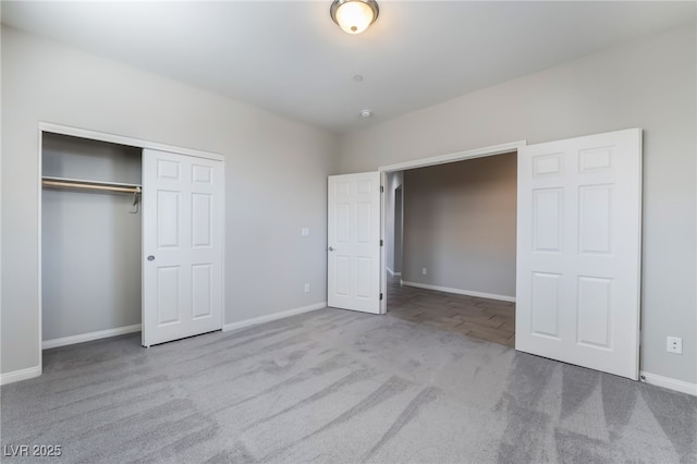 unfurnished bedroom with light colored carpet and a closet