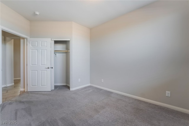 unfurnished bedroom featuring light colored carpet and a closet