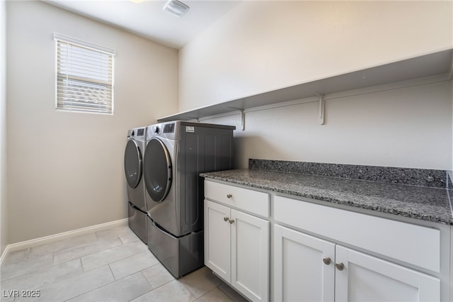 clothes washing area featuring cabinets, washer and dryer, and light tile patterned floors