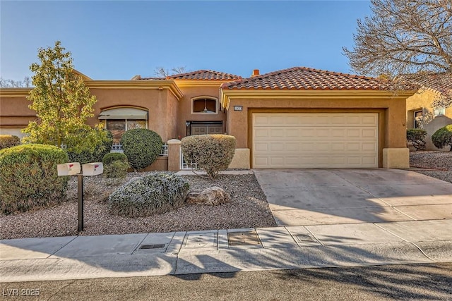 mediterranean / spanish-style house featuring a garage, concrete driveway, a tile roof, and stucco siding