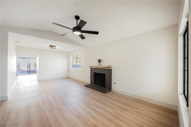 unfurnished living room with ceiling fan, lofted ceiling, light wood-type flooring, and a fireplace