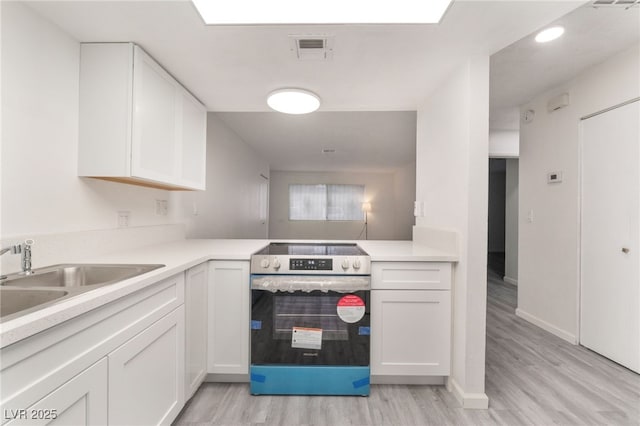 kitchen featuring white cabinetry, light countertops, visible vents, and stainless steel electric stove