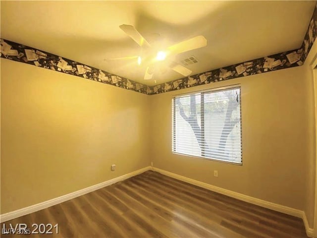 empty room with dark wood-type flooring and ceiling fan