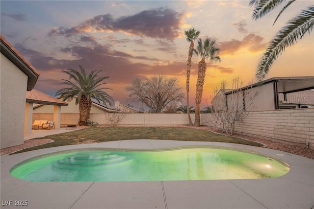 pool at dusk with a patio area