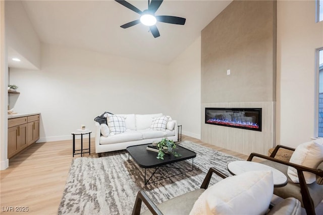 living room with ceiling fan, high vaulted ceiling, and light hardwood / wood-style floors