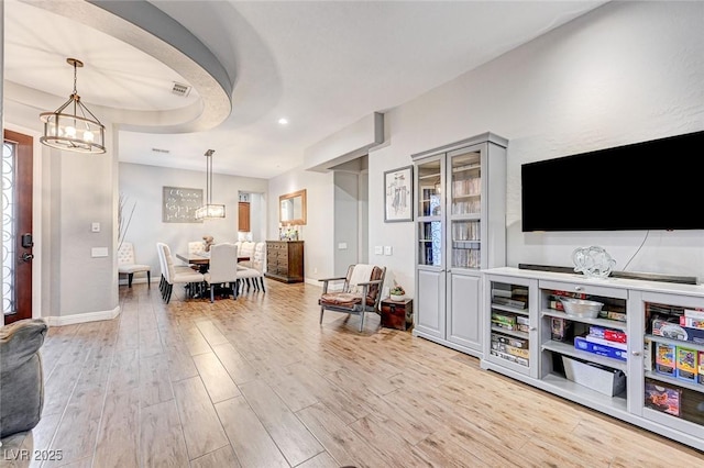 living room featuring light hardwood / wood-style flooring and a chandelier