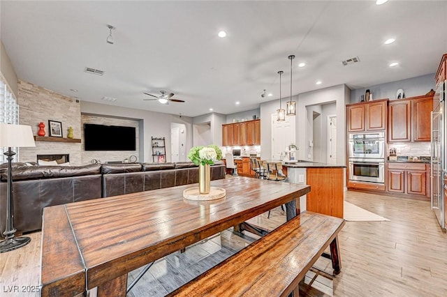 dining space with ceiling fan, sink, and light hardwood / wood-style floors