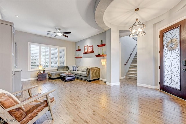 entryway with ceiling fan with notable chandelier and light hardwood / wood-style flooring