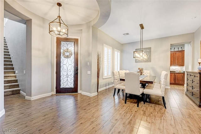 entryway with an inviting chandelier and light hardwood / wood-style flooring