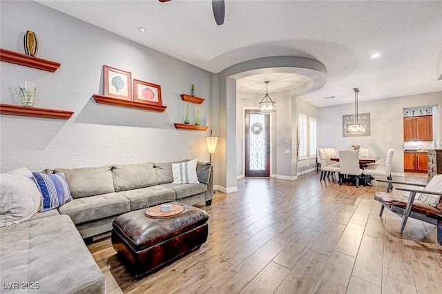 living room featuring ceiling fan and light hardwood / wood-style floors