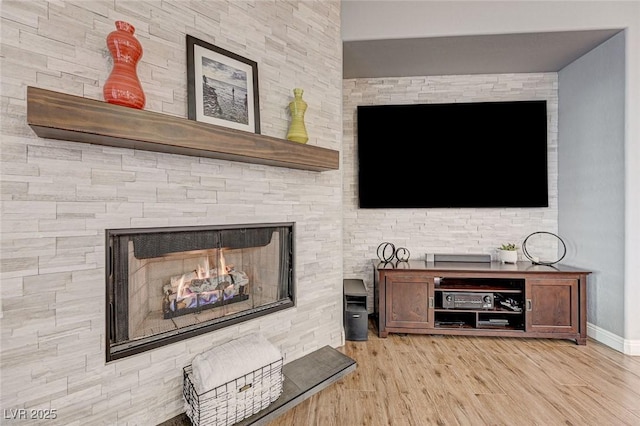 living room with light hardwood / wood-style flooring and a multi sided fireplace