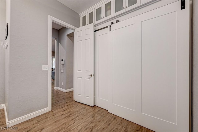 mudroom with light hardwood / wood-style floors and a barn door