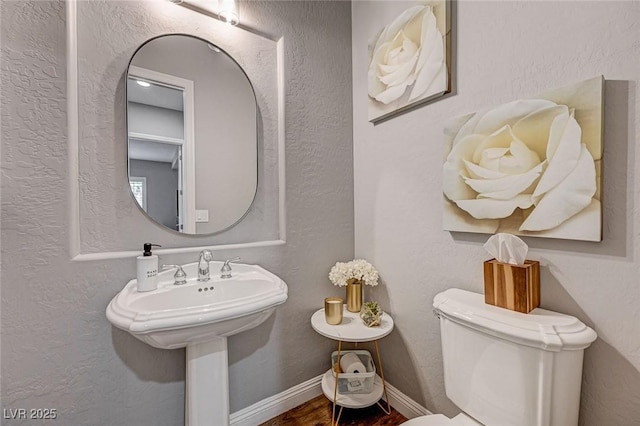 bathroom featuring toilet and wood-type flooring