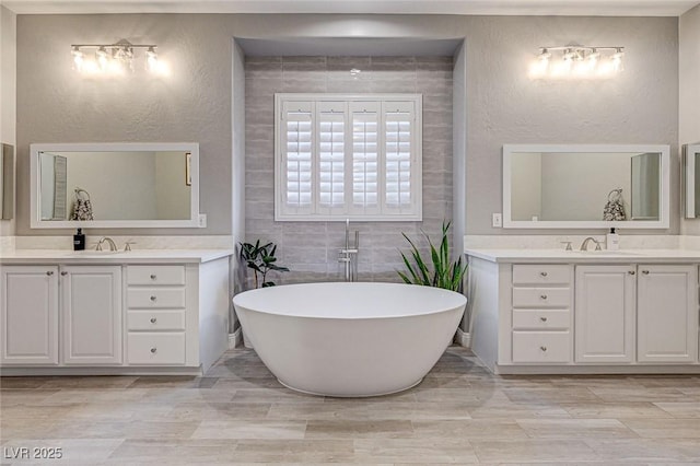 bathroom featuring vanity and a washtub