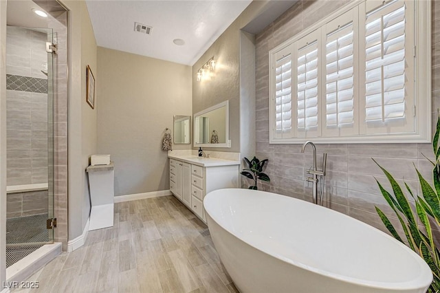 bathroom with hardwood / wood-style flooring, vanity, and independent shower and bath