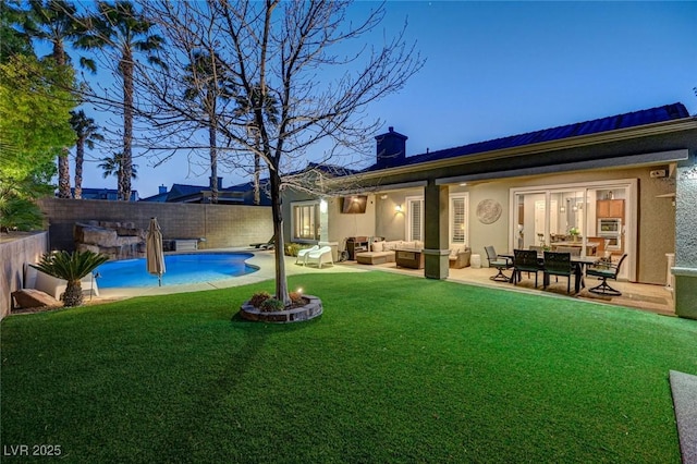 back of house with an outdoor hangout area, a patio area, a fenced in pool, and a yard