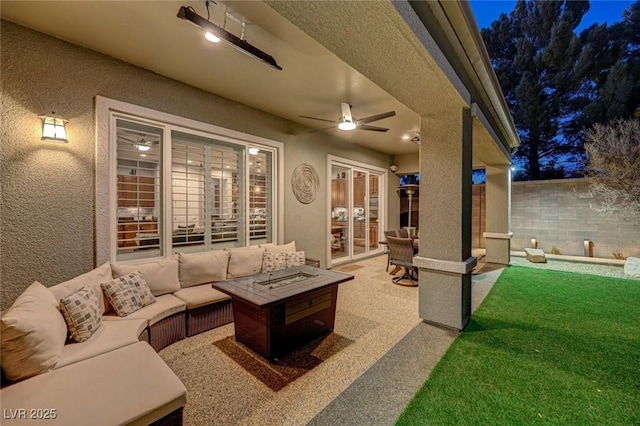 view of patio featuring ceiling fan and an outdoor living space with a fire pit