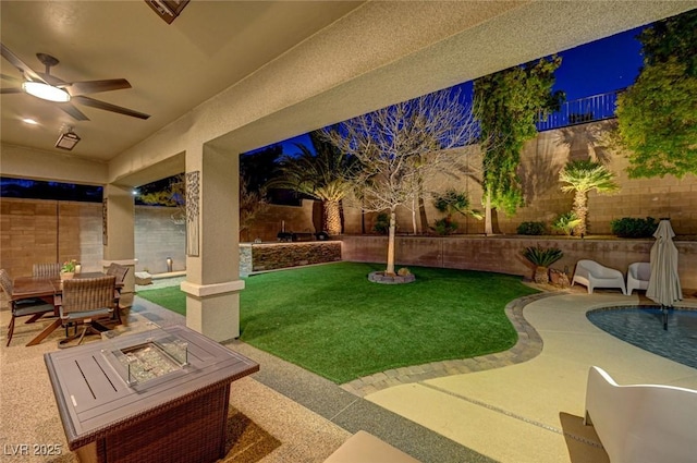 exterior space featuring ceiling fan, a patio area, and an outdoor fire pit